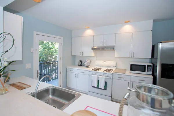 a kitchen that has a sink cabinets counter space and appliances