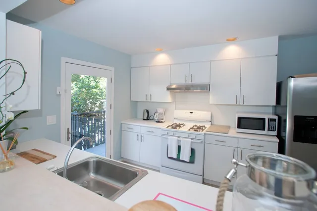 a kitchen that has a sink cabinets counter space and appliances
