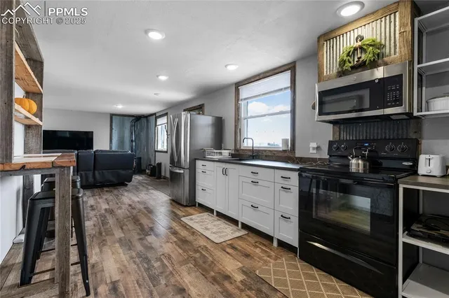 a kitchen with stainless steel appliances granite countertop a refrigerator and a stove top oven