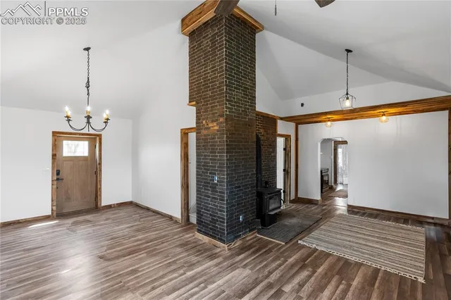 a view of a hallway with wooden floor and a chandelier