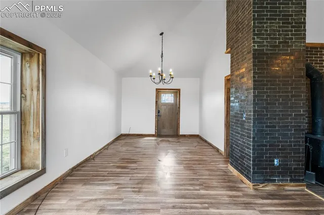 a view of a hallway with wooden floor and a potted plant