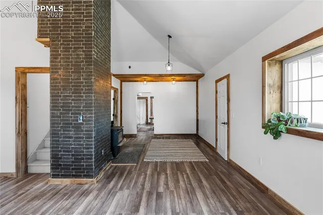 a view of a hallway with chandelier and wooden floor