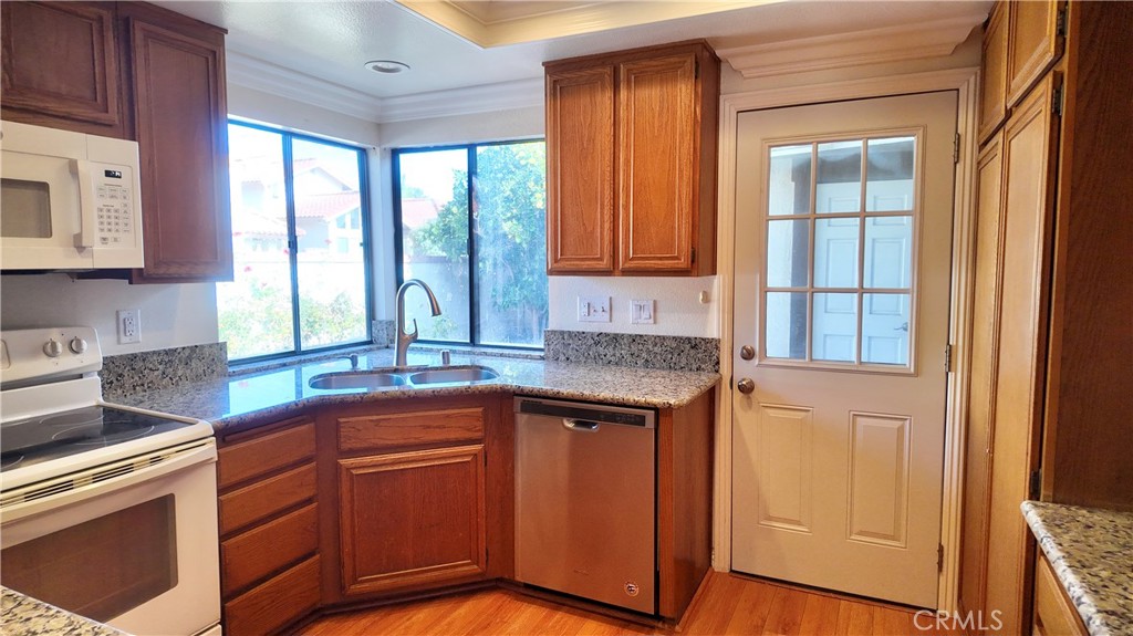 17 Filare Irvine, CA 92620 - Photo 7 of 16 a kitchen with stainless steel appliances granite countertop wooden cabinets a sink and a large window