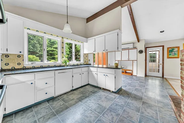 a large white kitchen with a large window