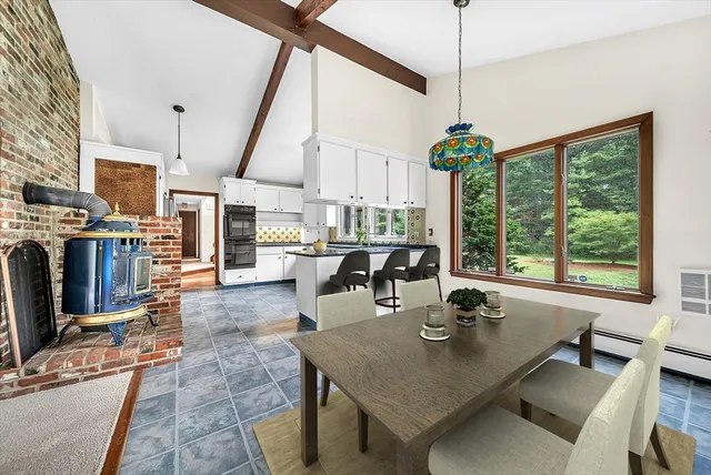 a dining room with stainless steel appliances granite countertop a table chairs and a view of kitchen