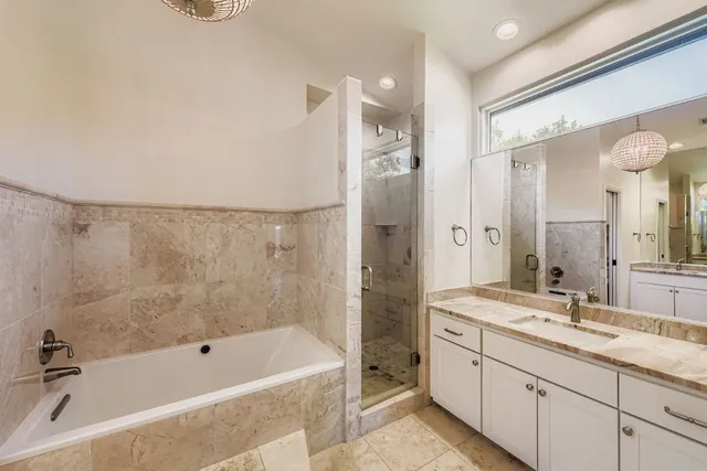a bathroom with a tub sink shower and mirror