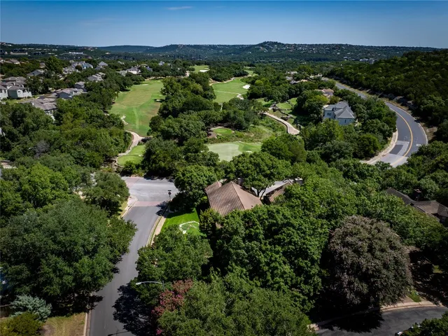 an aerial view of residential house with outdoor space and trees all around