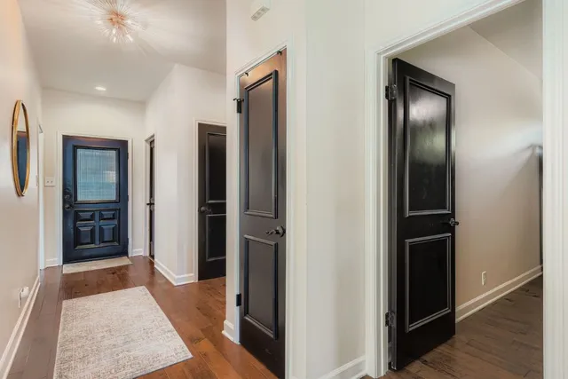 a view of a hallway with wooden floor and closet
