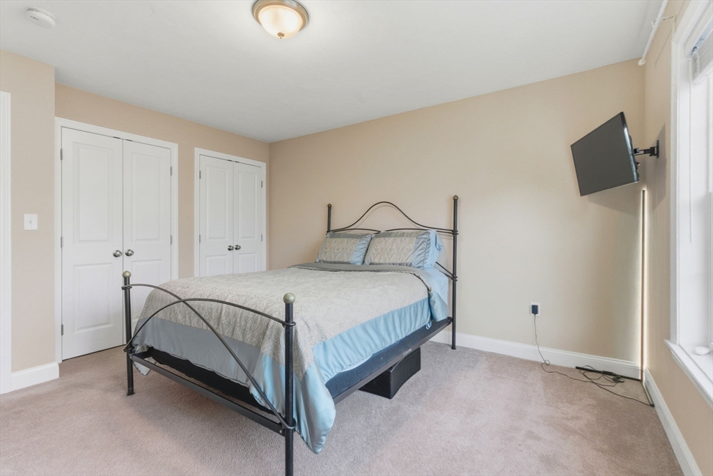 66 Compass Point, Unit 66 North Andover, MA 01845 - Photo 35 of 42 a bedroom with a bed and a flat tv screen on dresser