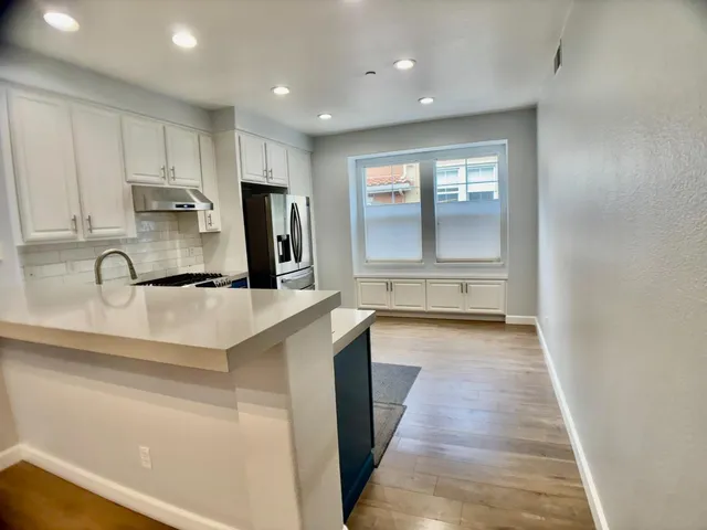 a kitchen with stainless steel appliances granite countertop a refrigerator sink and cabinets