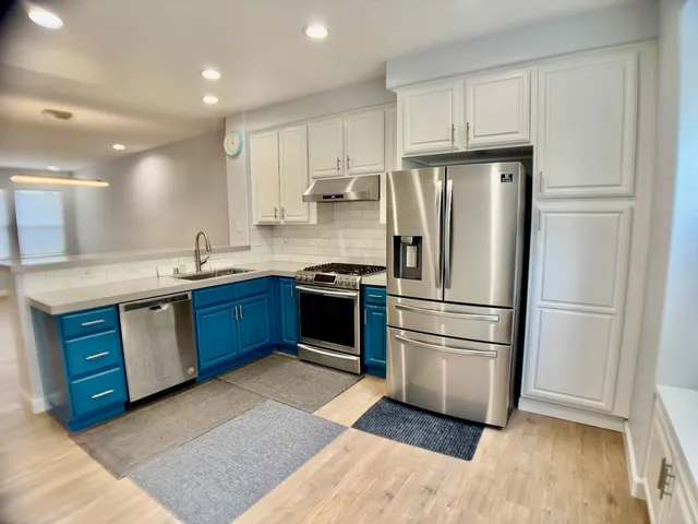 a kitchen with stainless steel appliances granite countertop a refrigerator sink and cabinets