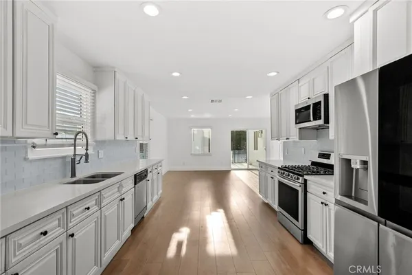 a kitchen with stainless steel appliances granite countertop a sink stove and refrigerator