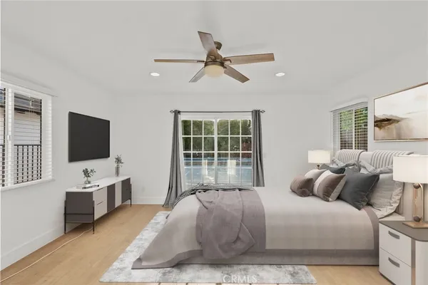 a bedroom with a bed window and a flat screen tv