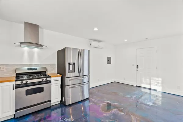a kitchen with stainless steel appliances a refrigerator and a stove top oven
