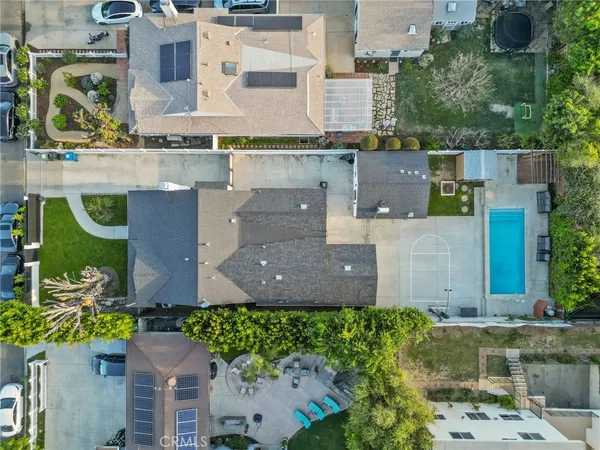 an aerial view of residential houses with outdoor space and parking