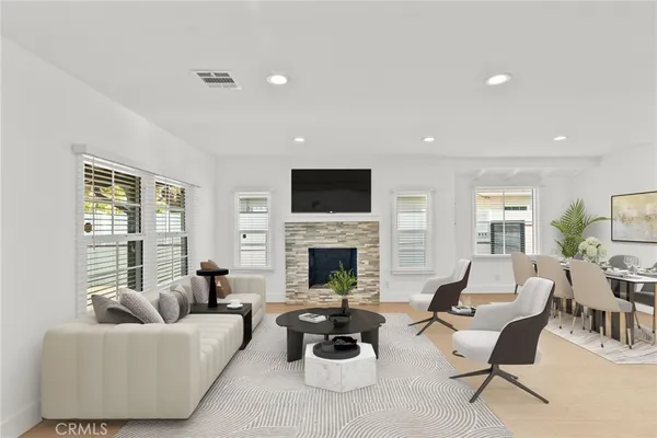 a living room with furniture a fireplace and a large window