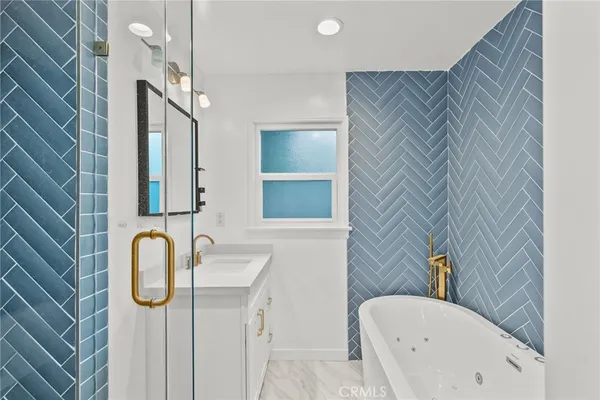 a bathroom with a tub sink and mirror