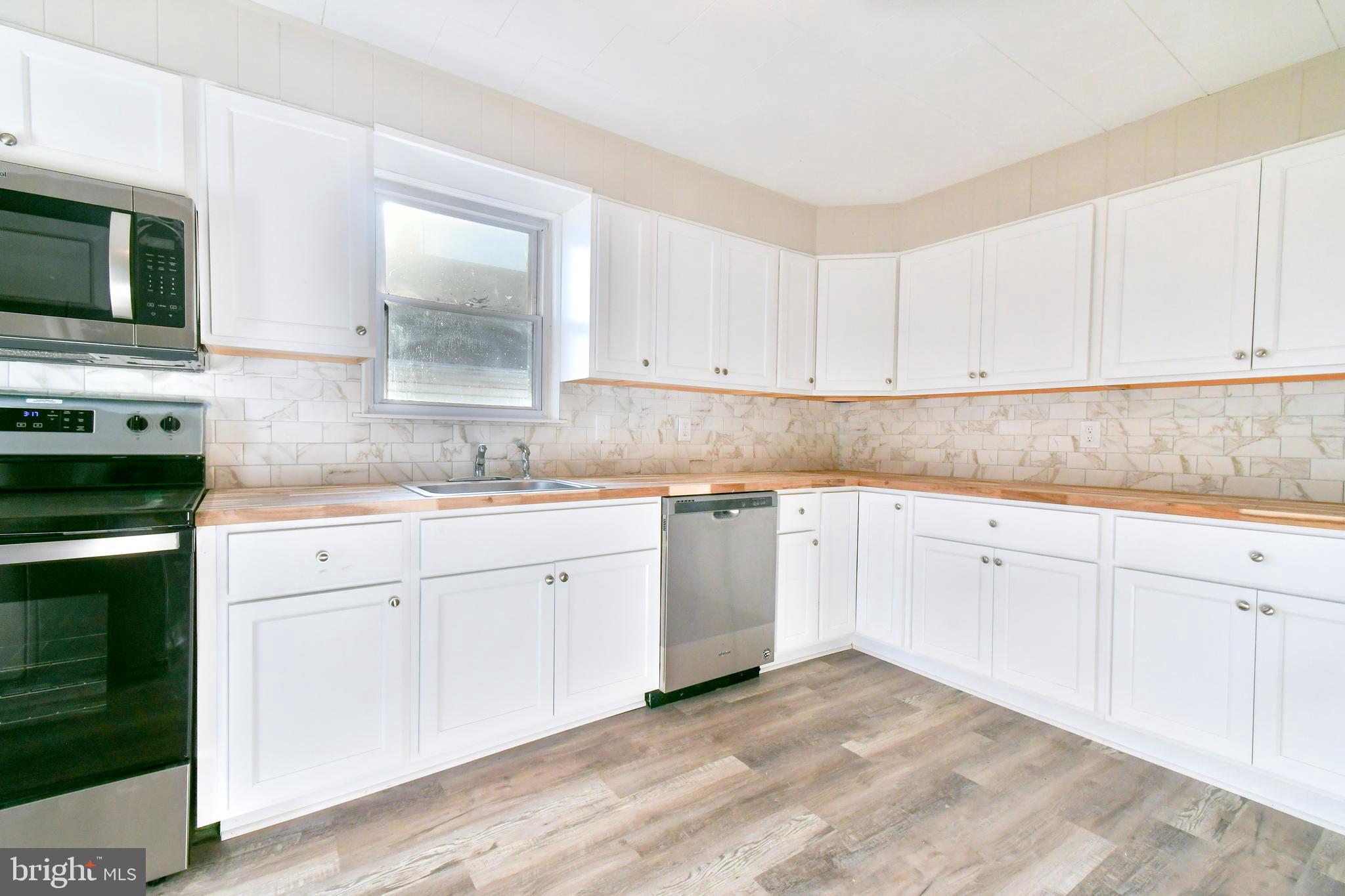 7618 Spruce Road Baltimore, MD 21222 - Photo 19 of 42 a kitchen with granite countertop white cabinets and stainless steel appliances