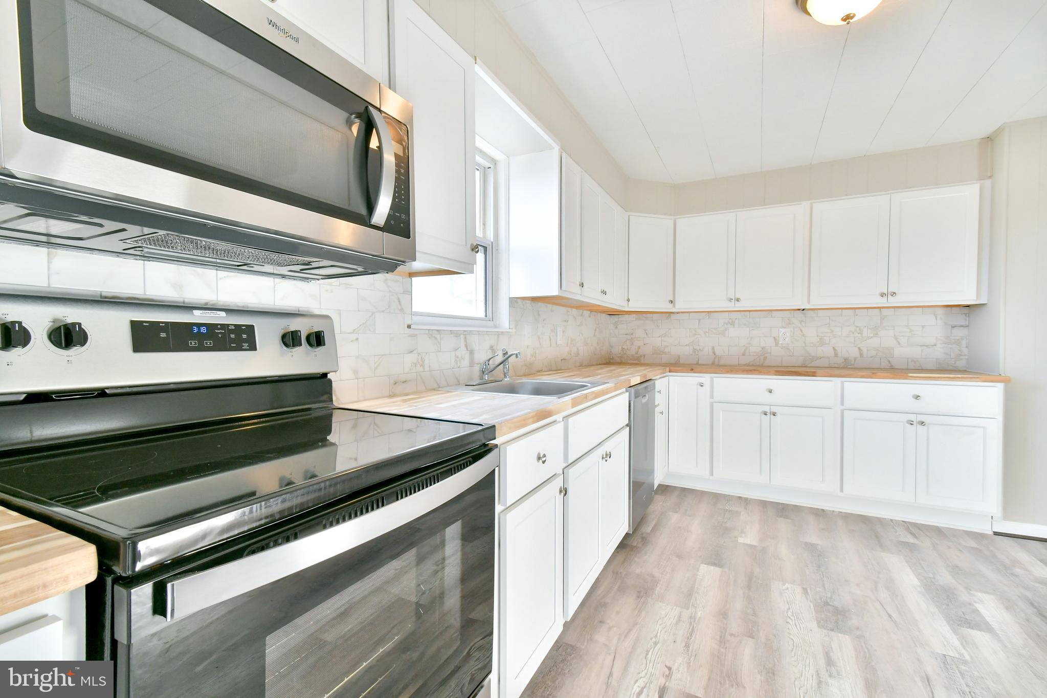 7618 Spruce Road Baltimore, MD 21222 - Photo 20 of 42 a kitchen with granite countertop a stove oven and white cabinets