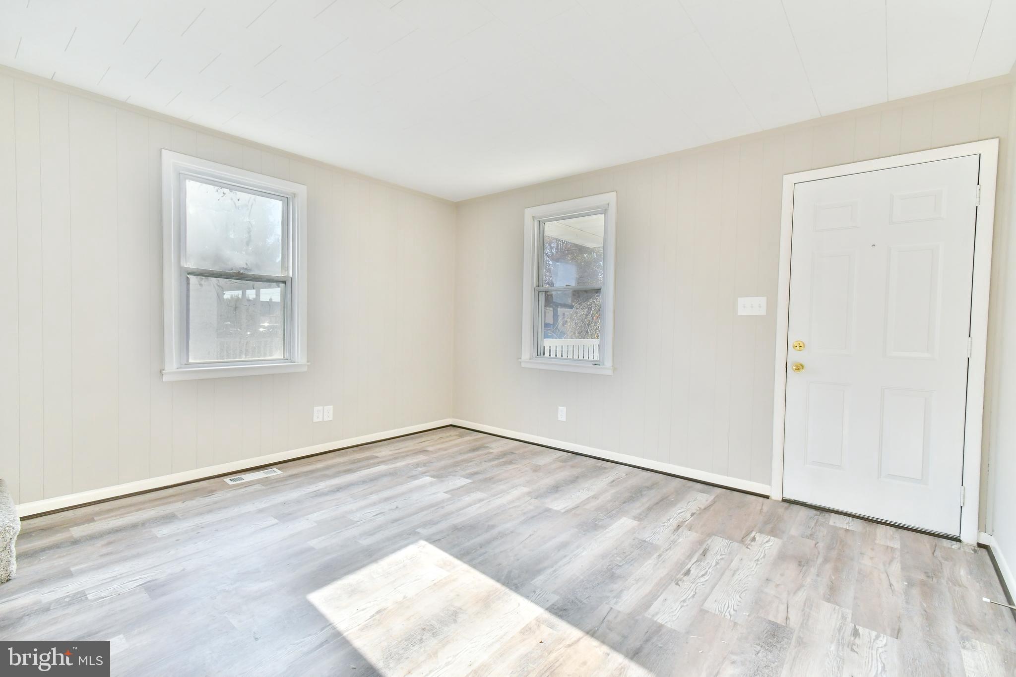 7618 Spruce Road Baltimore, MD 21222 - Photo 8 of 42 a view of an empty room with wooden floor and a window
