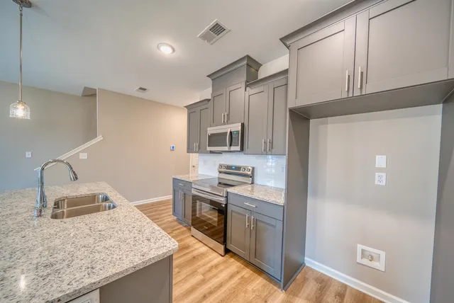 a kitchen with appliances a sink and cabinets