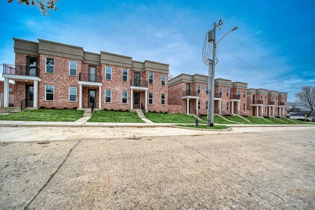 a front view of a building with a garden