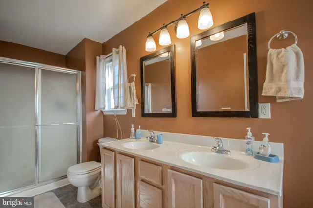 a bathroom with a granite countertop toilet sink and a mirror