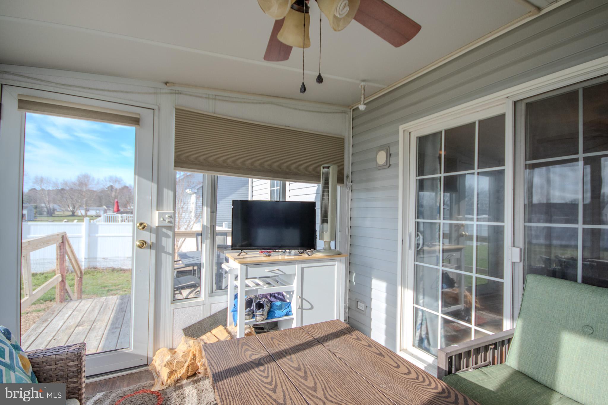 30071 Deanwood Road Princess Anne, MD 21853 - Photo 30 of 37 a living room with furniture a flat screen tv and a floor to ceiling window