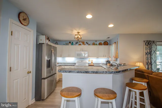 a kitchen with stainless steel appliances granite countertop a sink and a refrigerator
