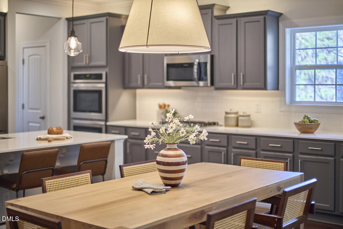 8600 Rowan Oak Court Wake Forest, NC 27587 - Photo 11 of 42 a kitchen with a table chairs sink and microwave