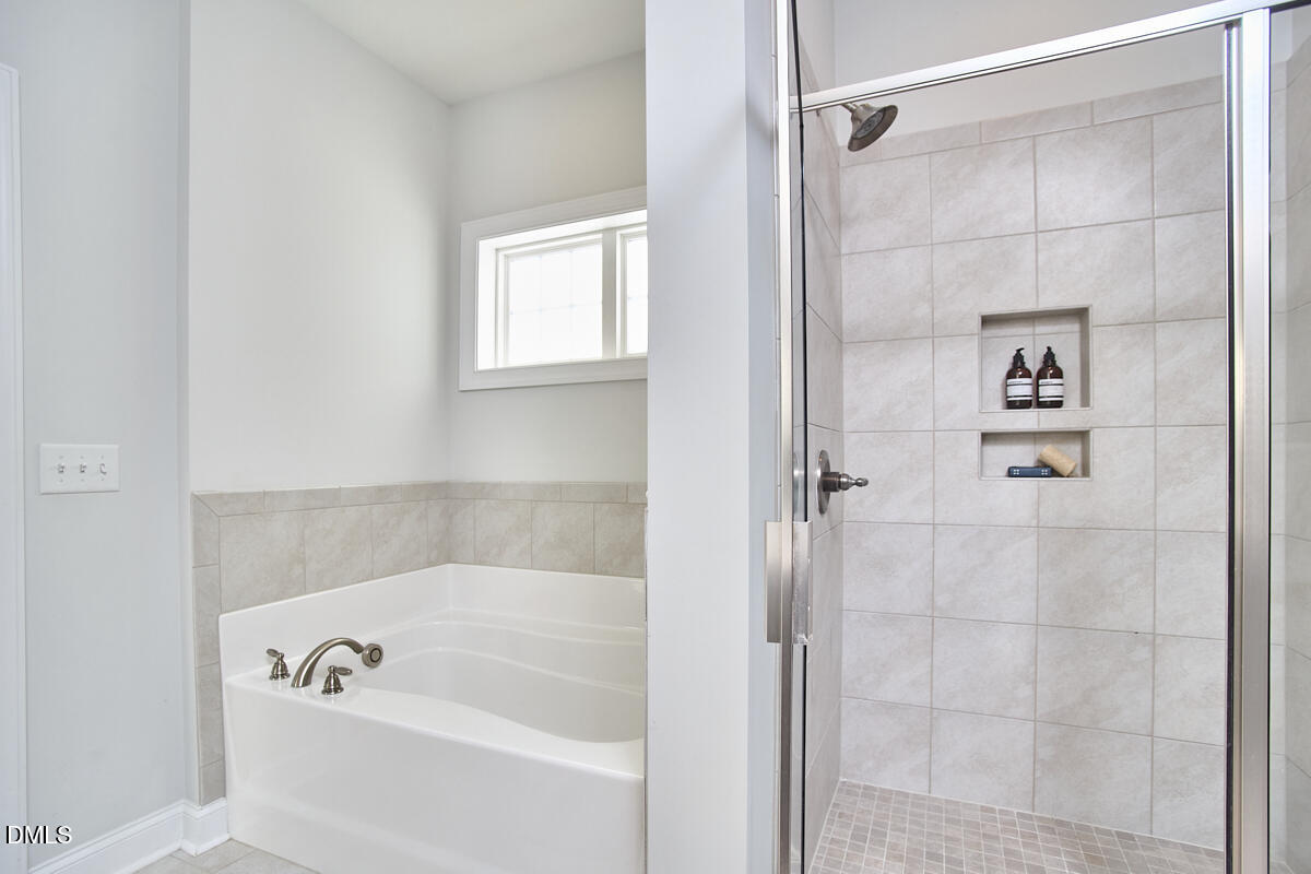 8600 Rowan Oak Court Wake Forest, NC 27587 - Photo 23 of 42 a bathroom with a bathtub and a shower