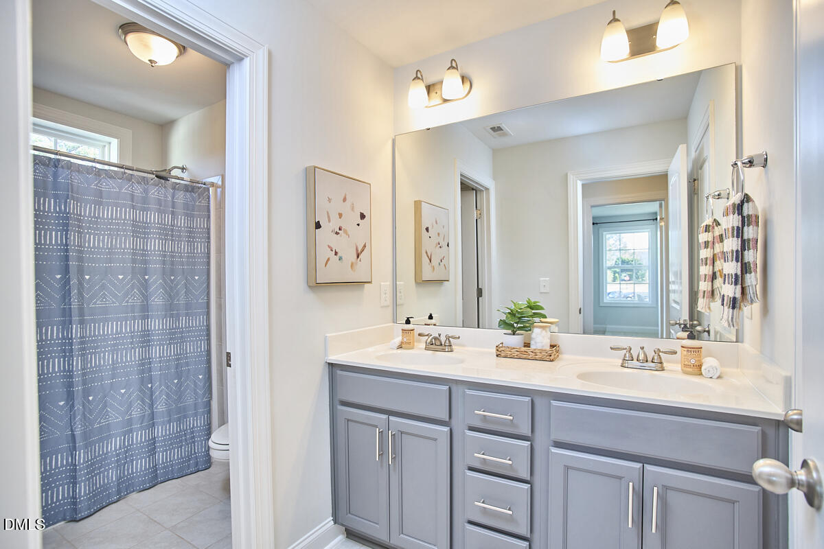 8600 Rowan Oak Court Wake Forest, NC 27587 - Photo 32 of 42 a bathroom with a double vanity sink mirror and double