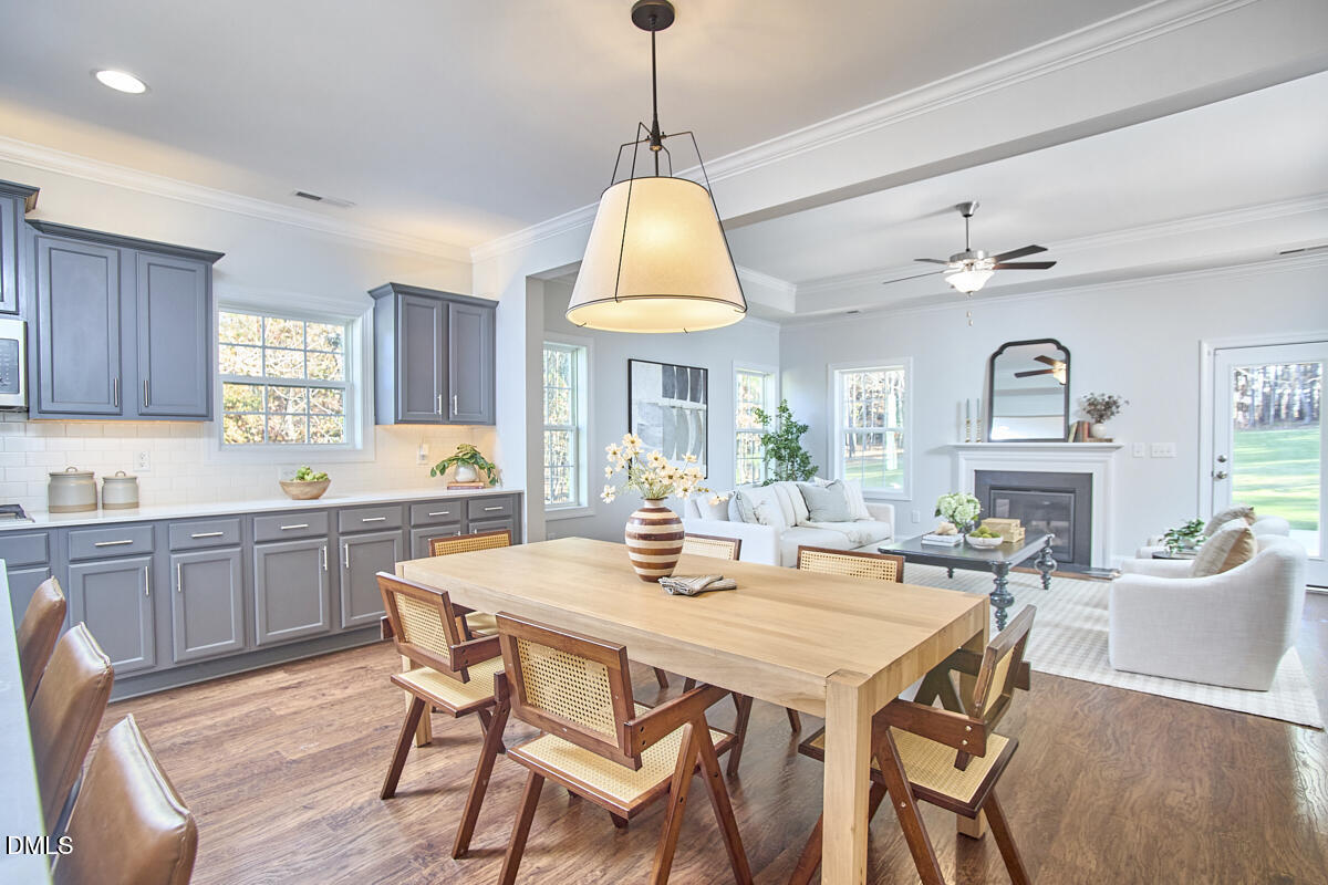 8600 Rowan Oak Court Wake Forest, NC 27587 - Photo 8 of 42 a dining room with wooden floor a chandelier a wooden table and chairs