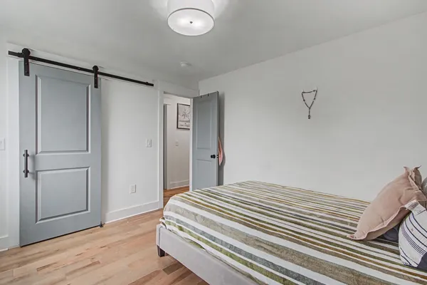 a bedroom with a bed and wooden floor