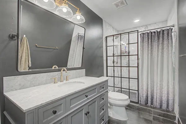 a bathroom with a toilet a sink and mirror