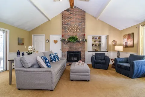 a living room with furniture fireplace and a large window