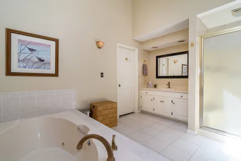 a bathroom with a tub sink and mirror
