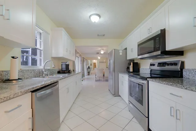 a large kitchen with stainless steel appliances granite countertop a sink and cabinets