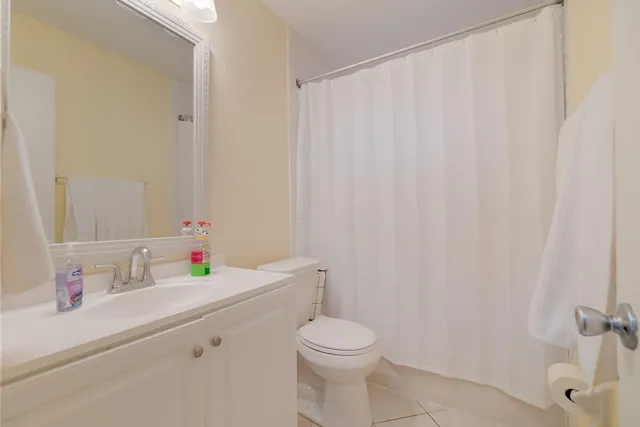 a bathroom with a sink a toilet and shower curtain