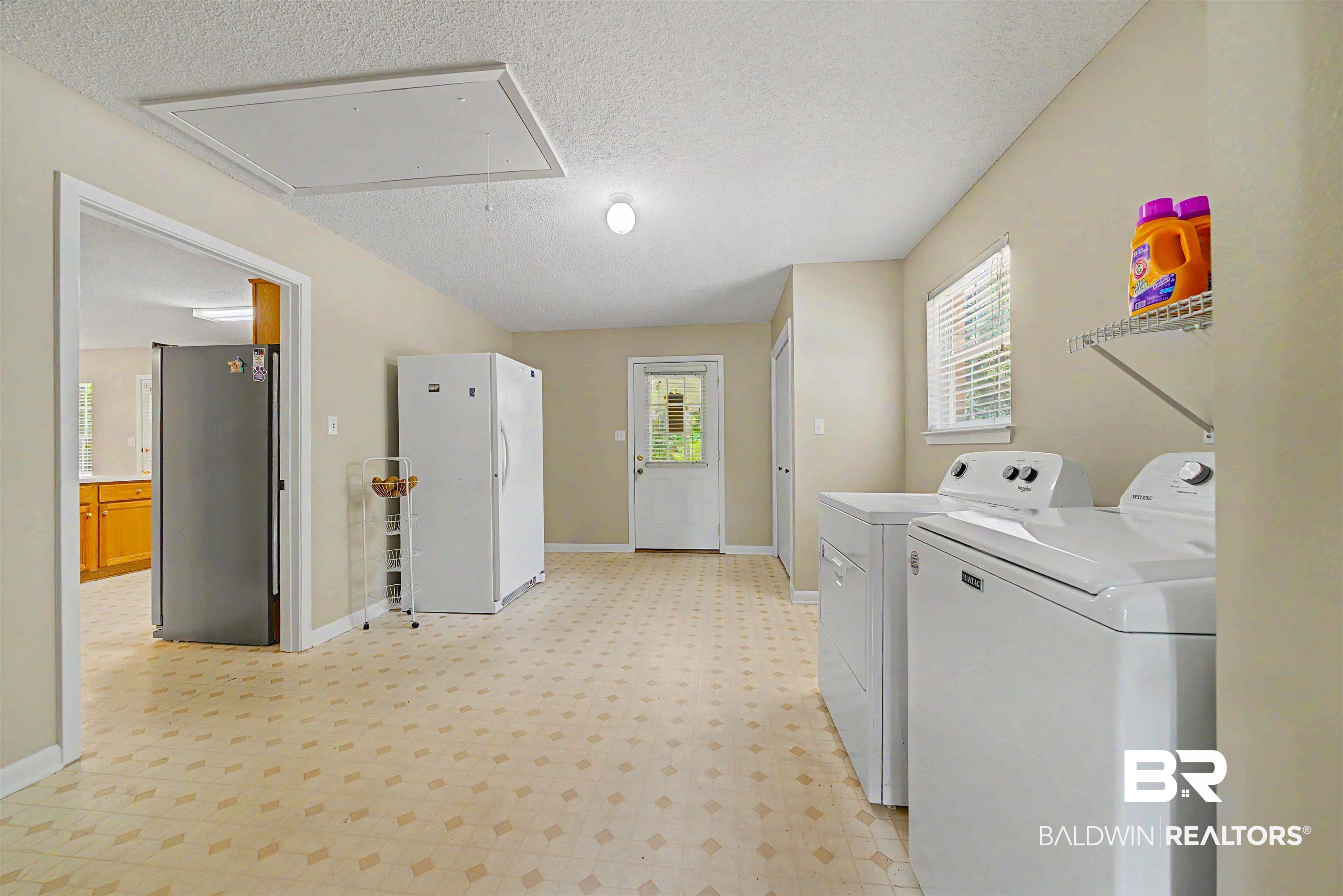 22963 Highway 98 Foley, AL 36535 - Photo 32 of 52 Utility room featuring patterned vinyl flooring, a built-in wall shelf, a window with blinds, and a ceiling access panel