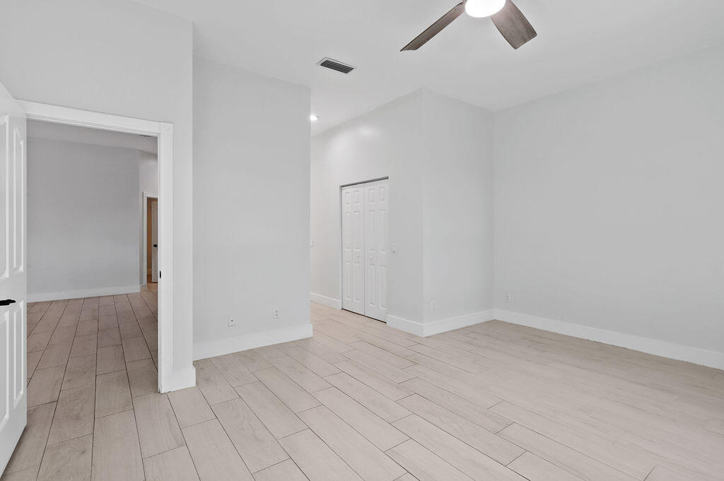 168 South Hampton Drive Jupiter, FL 33458 - Photo 12 of 33 an empty room with chandelier fan and windows