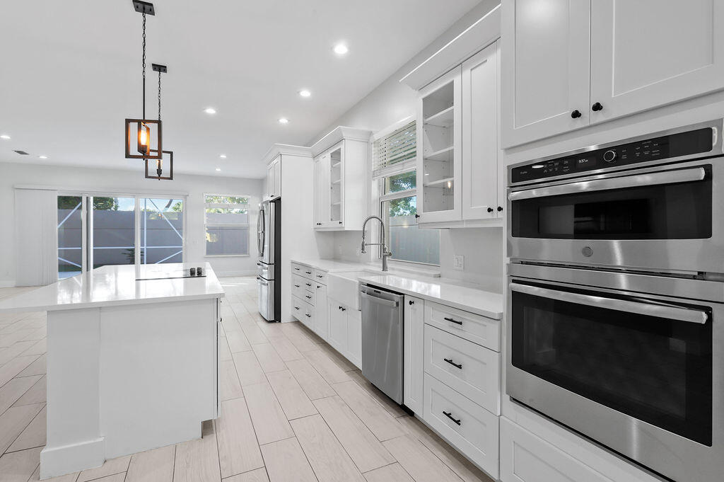 168 South Hampton Drive Jupiter, FL 33458 - Photo 3 of 33 a kitchen with stainless steel appliances kitchen island granite countertop a stove a sink and a refrigerator