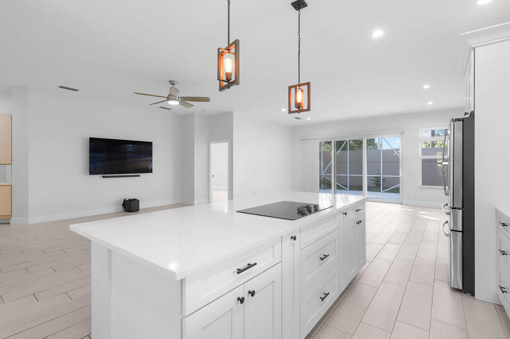 168 South Hampton Drive Jupiter, FL 33458 - Photo 4 of 33 a large white kitchen with a large window and stainless steel appliances