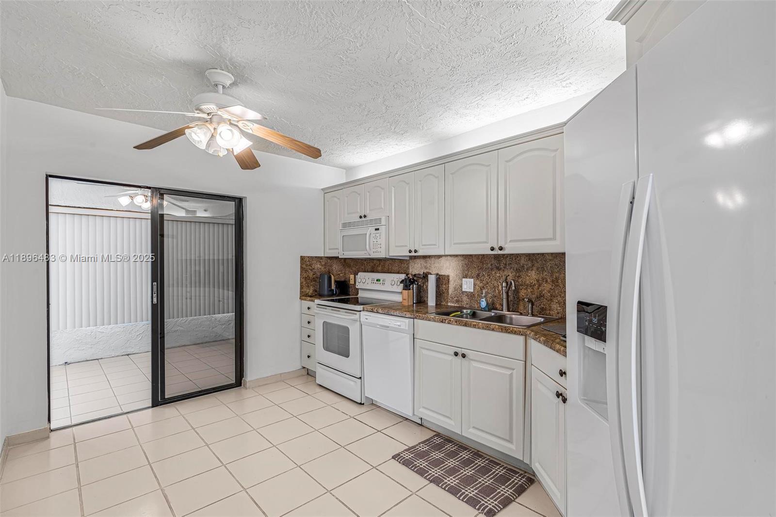 7507 La Paz Boulevard, Unit 407 Boca Raton, FL 33433 - Photo 11 of 34 a kitchen with white cabinets and appliances