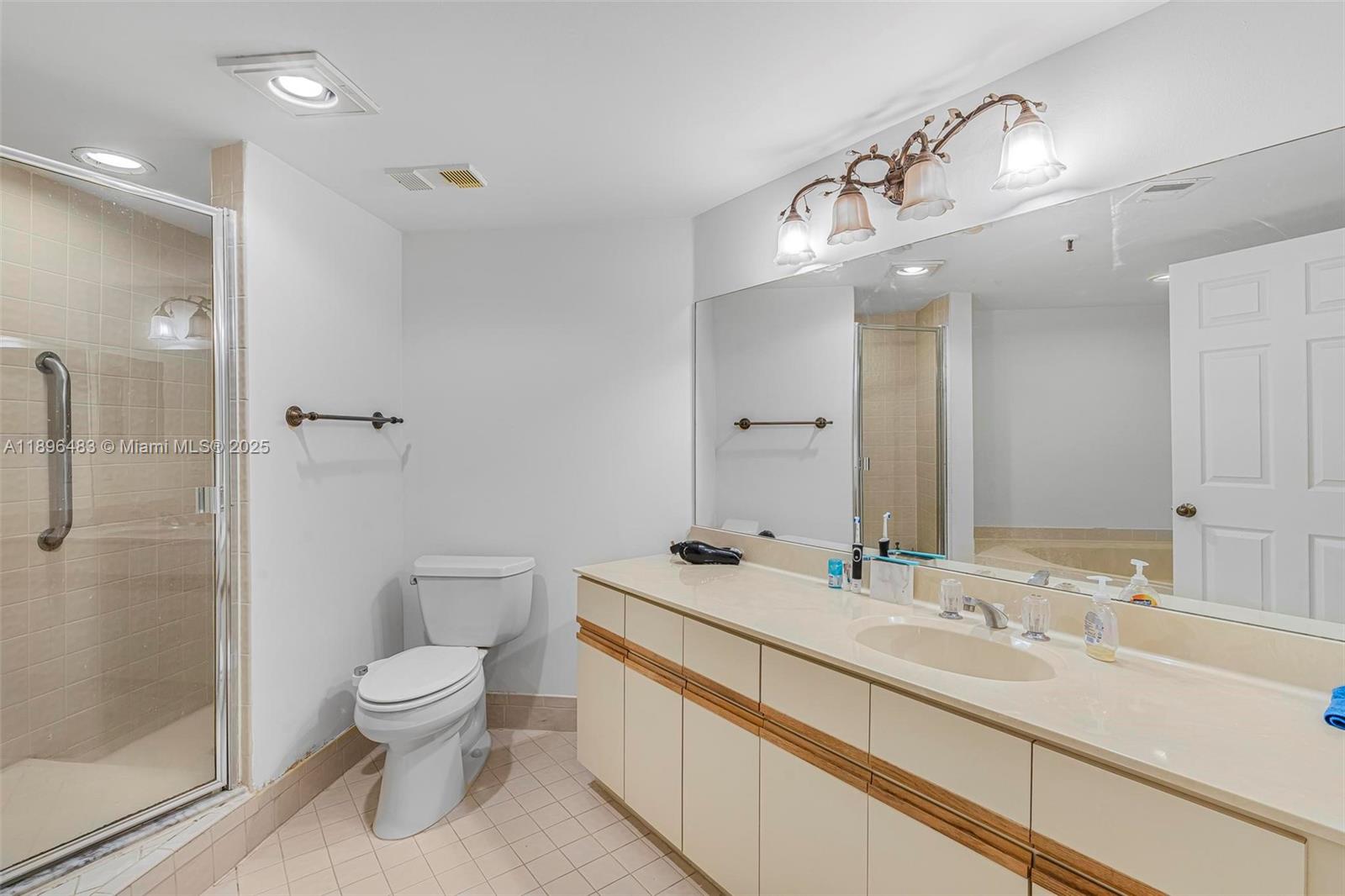 7507 La Paz Boulevard, Unit 407 Boca Raton, FL 33433 - Photo 21 of 34 a bathroom with a sink a toilet and shower