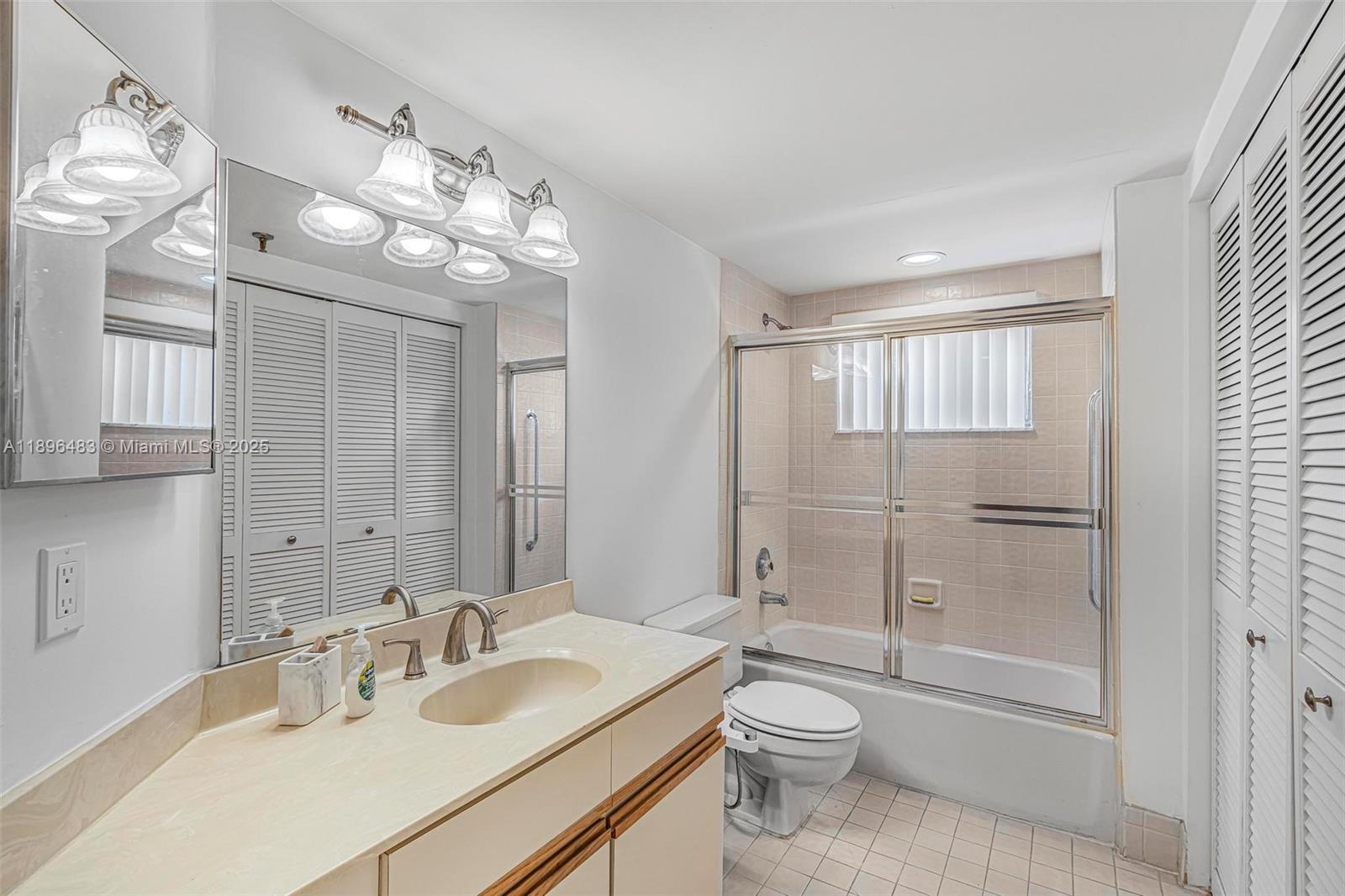 7507 La Paz Boulevard, Unit 407 Boca Raton, FL 33433 - Photo 27 of 34 a bathroom with a toilet a sink a mirror and a shower