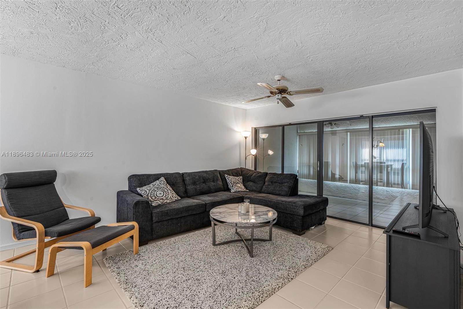 7507 La Paz Boulevard, Unit 407 Boca Raton, FL 33433 - Photo 7 of 34 a living room with furniture and a ceiling fan