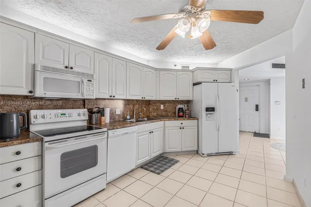 a kitchen with white cabinets and white appliances