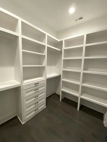 a view of walk in closet with empty racks
