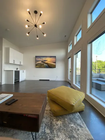 a living room with furniture and a open kitchen view